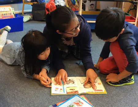 Students reading a book in their mother tongue